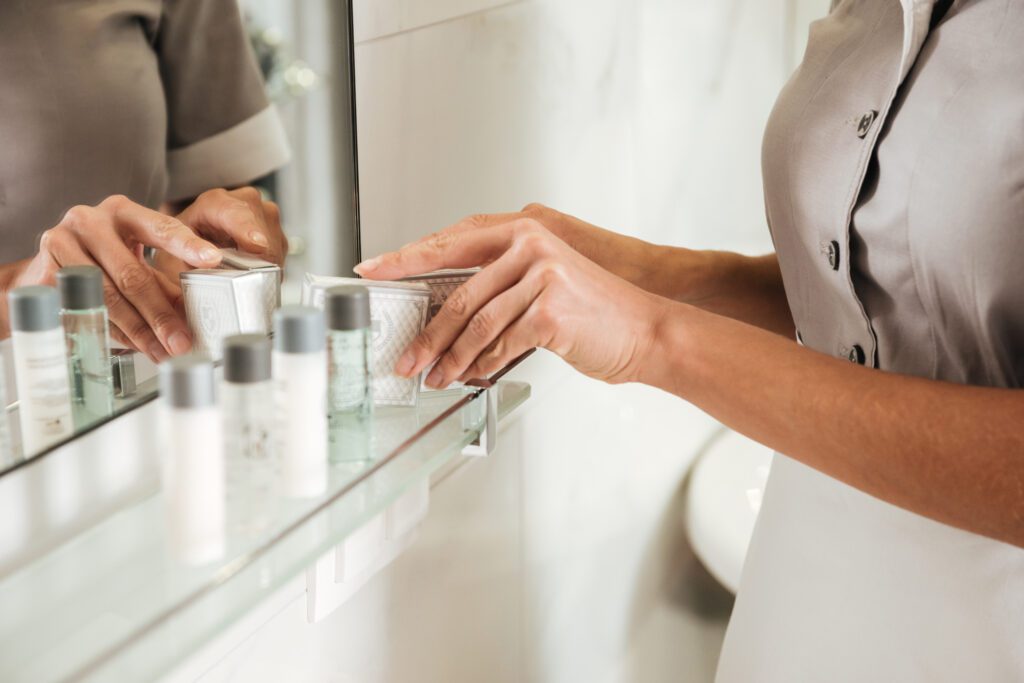 Image of housekeeping staff placing new shampoo from SLA shampoo supplier